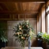 Floral wreath with cream and peach roses on a stand