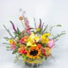 Colorful mixed flower basket with sunflowers, roses, and orchids