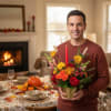 Man holding a fall floral arrangement in a gold vase