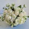 White roses and hydrangeas arranged in a low bowl vase