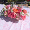Lush, low-profile centerpiece of roses, ranunculus, &amp; silver dollar eucalyptus