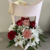 Pink gift box with red roses, pink carnations, and white daisies