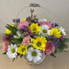 Basket arrangement of daisies, roses, and carnations in pink, yellow, white, and purple