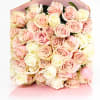 Bouquet of pale pink and cream roses wrapped in pink paper
