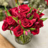 Red roses and pink tulips arranged in a clear glass vase