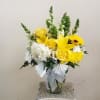 Yellow and white flower arrangement in a clear glass vase