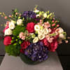 Mixed bouquet of roses, hydrangeas, and pink blooms in a vase