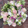 Round bouquet of pink and white roses with lavender flowers
