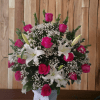 Pink roses and white lilies in a vase with baby's breath