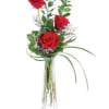Tall red rose arrangement in a clear glass vase