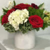 Red roses and white hydrangea in a white vase