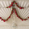 Red rose buds arranged around a hanging cross ornament