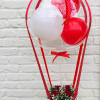 Red and white balloon arrangement with a small flower basket at the base