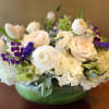 White and blush flowers arranged in a green glass bowl