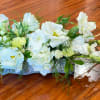 White floral centerpiece with orchids and roses on a low base