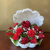Red roses and carnations in a white shell-shaped basket