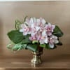 Pink and white orchids arranged in a gold vase
