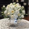 White rose and lisianthus bouquet in a clear glass vase