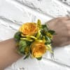 Yellow rose wrist corsage with ribbon and greenery