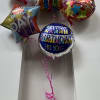 Birthday balloons tied to a teddy bear