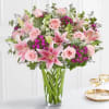 Pink roses and lilies arranged in a clear glass vase