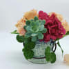 Succulent and pink flower arrangement in a blue ceramic pot
