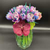 Colorful bouquet in a clear glass vase with a pink orchid front