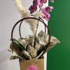 Purple orchid stems in a gift bag with dried pampas grass