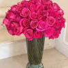 Bouquet of bright pink roses in a tall glass vase