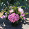 Pink hydrangea and mixed pastel flowers in a glass vase