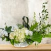White orchid and hydrangea arrangement in a low white vase