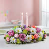 Low floral centerpiece with two pink candles and pastel flowers