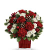 Red and white carnations in a red glass vase with pinecones