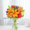 Orange and pink mixed bouquet in a clear glass vase