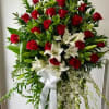 Standing spray of red roses and white lilies with a white ribbon