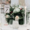 White and blush floral centerpiece with table number and tall candles
