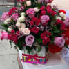 Pink and red rose bouquet in a birthday box beside a teddy bear