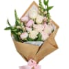 Bouquet of pale pink and cream roses wrapped in brown paper