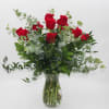 Red roses in a clear glass vase with airy greenery