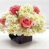 Pink roses arranged with white hydrangeas in a wooden box