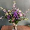 Purple and pink mixed bouquet in a clear glass vase
