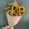 Bouquet of yellow sunflowers wrapped in beige paper