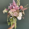 Handheld bouquet of pink orchids, roses, and white daisies