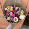 Bouquet of multicolored roses wrapped in brown paper