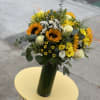 Share a smile with this lovely floral arrangement that includes sunflowers, roses