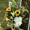 Bouquet of sunflowers, white lilies, and white hydrangea in a glass vase