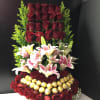 Tall arrangement of red roses, lilies, and gold-wrapped chocolates
