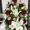 Arrangement of red roses, white lilies, and pink lisianthus