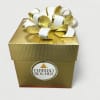 Gold Ferrero Rocher gift box with a white and gold ribbon bow