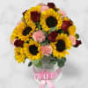 Bouquet of sunflowers, red roses, and pink carnations in a white box with a pink ribbon